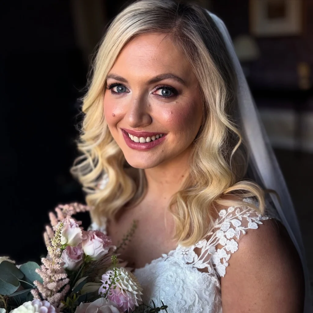 Blonde bride holding her boquette - soft glam wedding makeup
