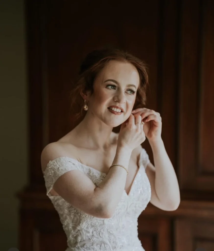 Fair skinned bride adjusting her earring - wedding makeup by Nima
