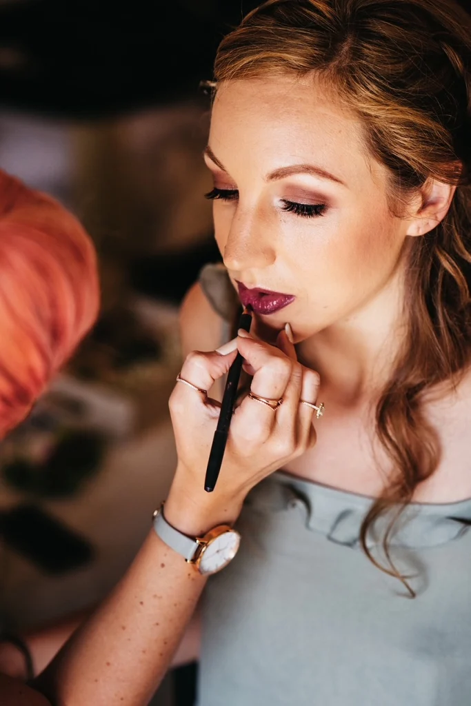 Makeup artist Nima applying dark lipstick for glam makeup