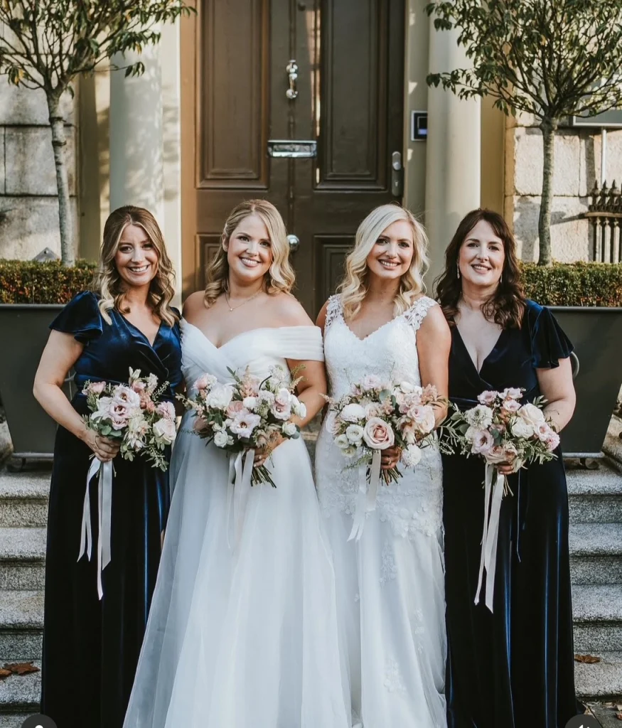Same-sex beautiful brides and their bridesmaids holding boquettes