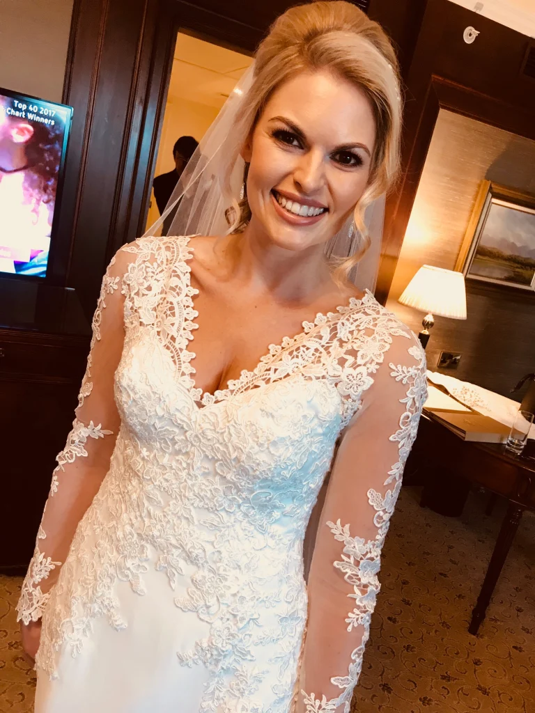 Gorgeous blonde bride showing off her dress and wedding makeup