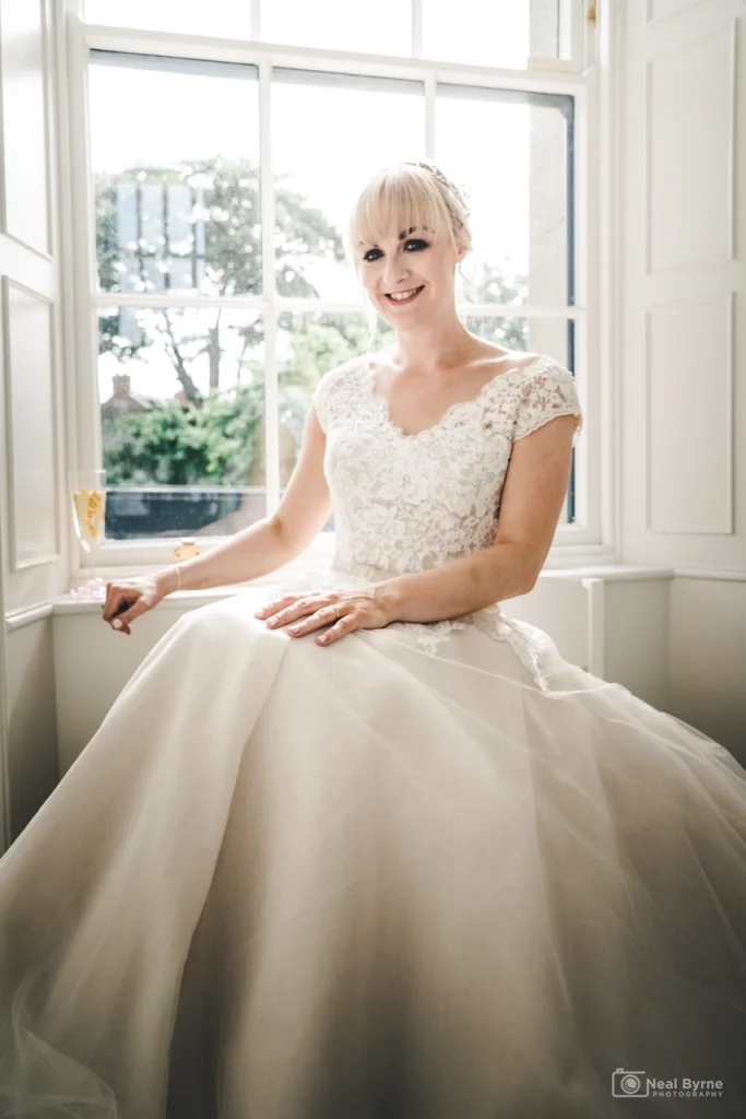 Striking blonde bride posing in her dress and wedding makeup
