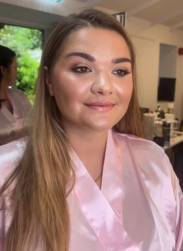 Pretty woman posing in pink robe after getting her makeup done by Dublin makeup artist Nima