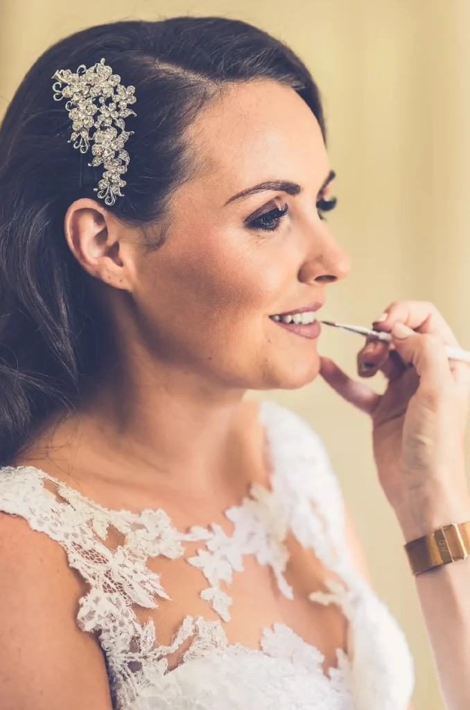 Nimah applying lipstick on a bride