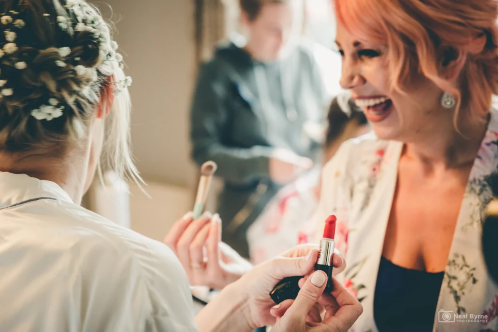 Bride and Nima laughing on the morning of the wedding as she's getting makeup applied